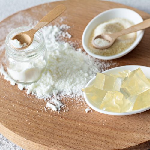 Products (collagen powder, gelatin) which contain collagen.Diced gelatin.Collagen powder on a light background. Extra protein intake. Natural beauty and health supplement for skin, bones, joints