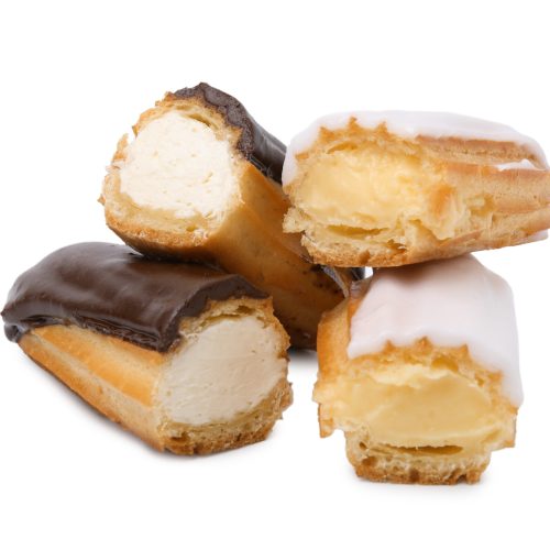 Many cut delicious eclairs isolated on white